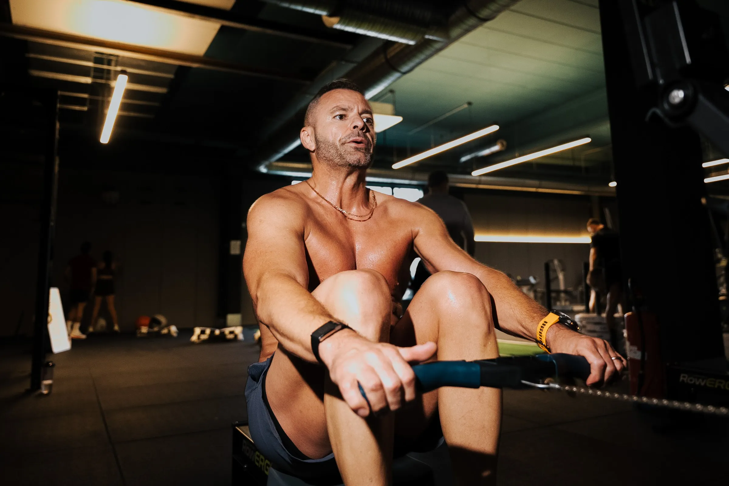 Athlete on a rowing machine in a dark gym
