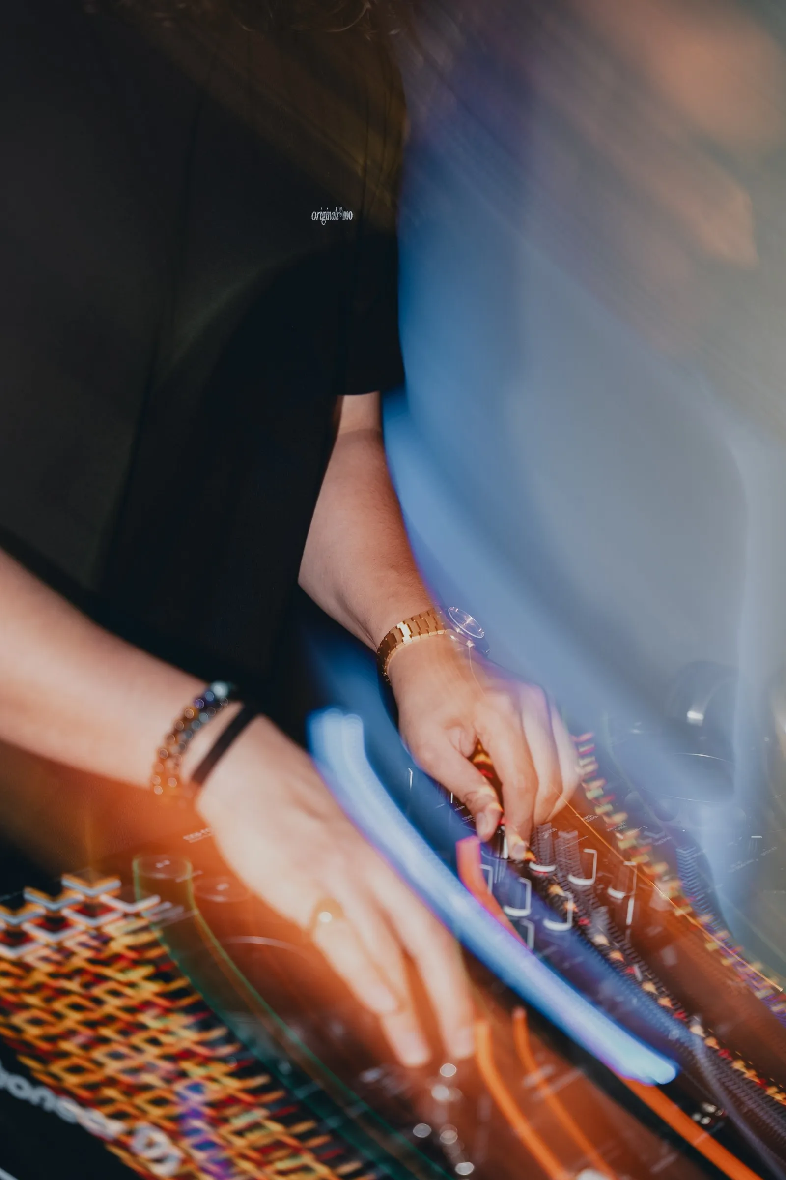 Hands of a DJ on the mixing desk, in motion