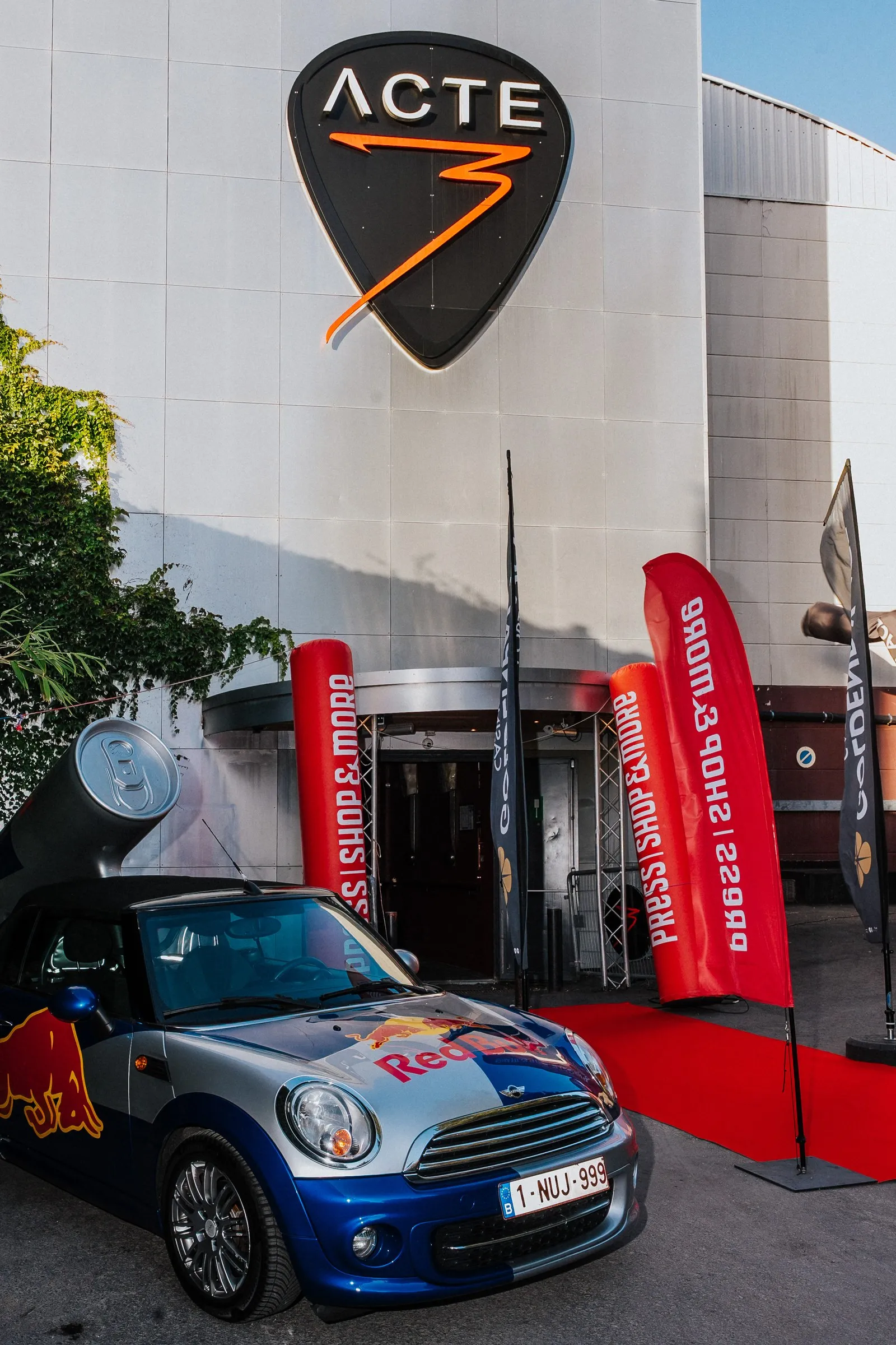 Venue entrance with red carpet and a sponsor-branded car