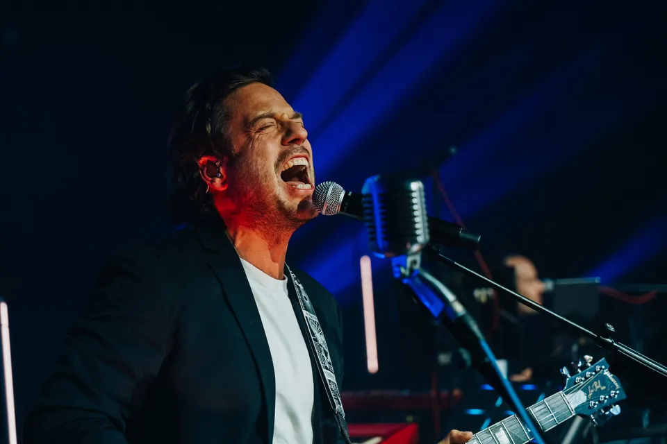 Chanteur au micro sur scène, lumière bleue