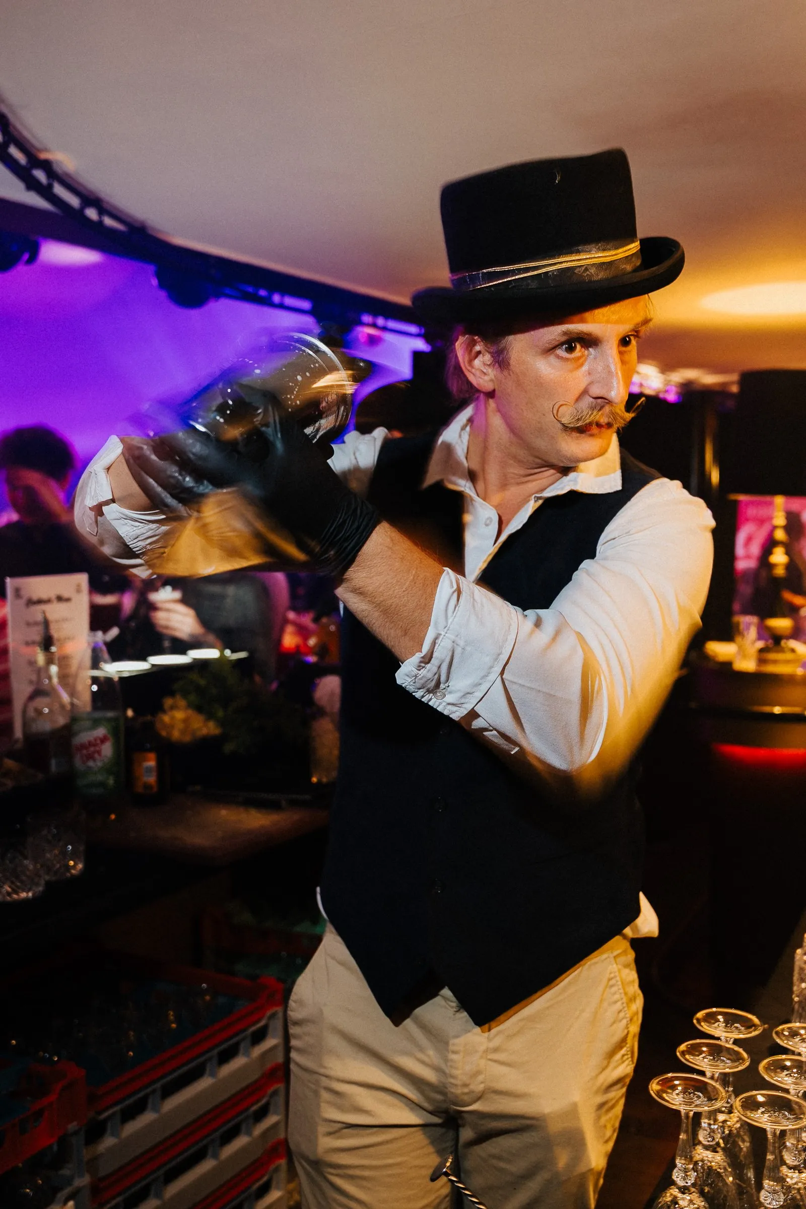 Barman en chapeau haut de forme préparant un cocktail