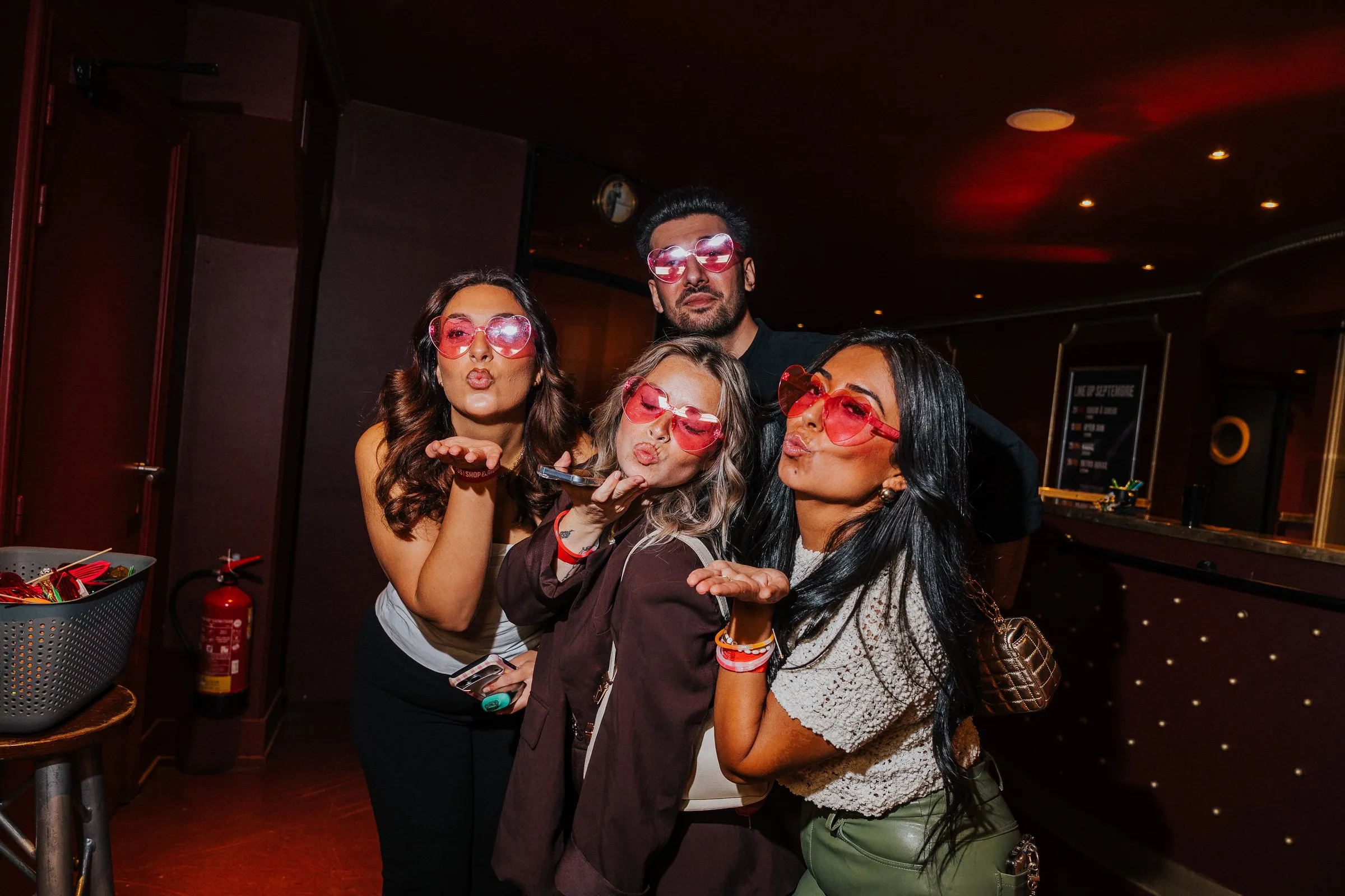 Groupe d'invités posant avec des lunettes roses